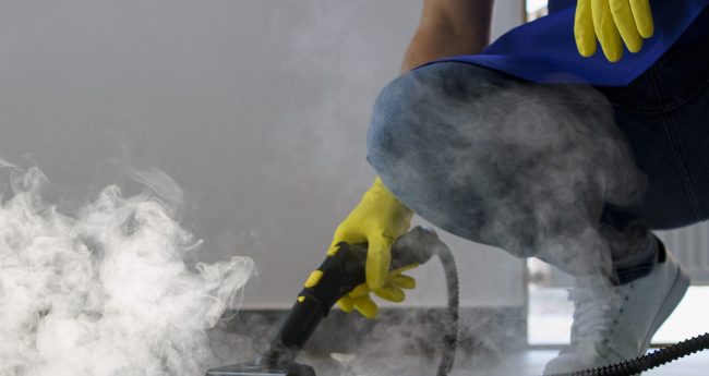 persona-de-servicio-de-limpieza-profesional-que-usa-limpiador-de-vapor-en-la-oficina